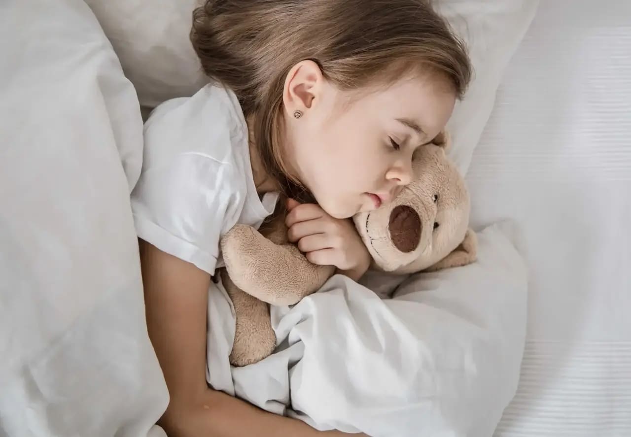 sleeping child with teddy bear